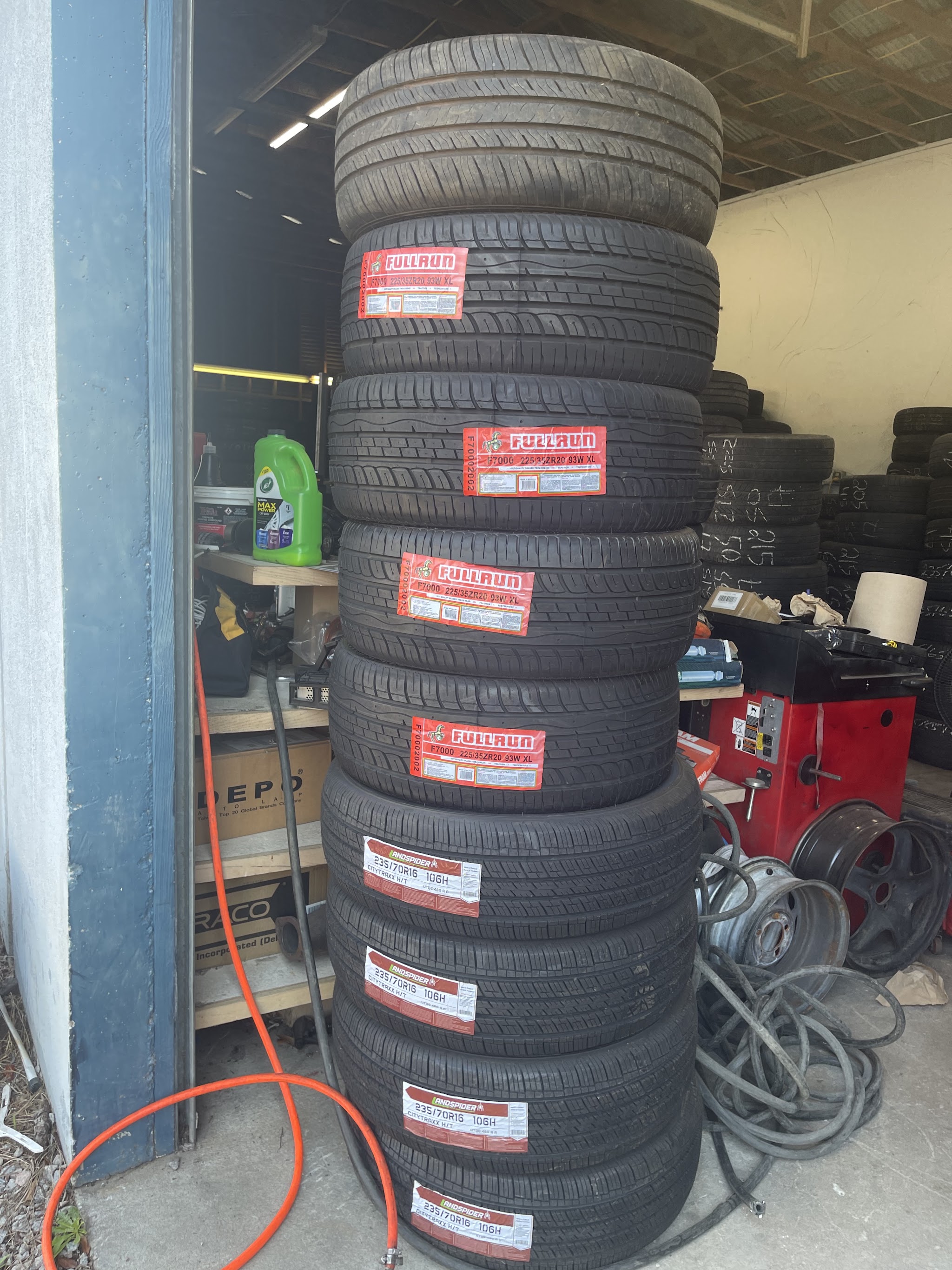 New tires stacked beside the balancing machine