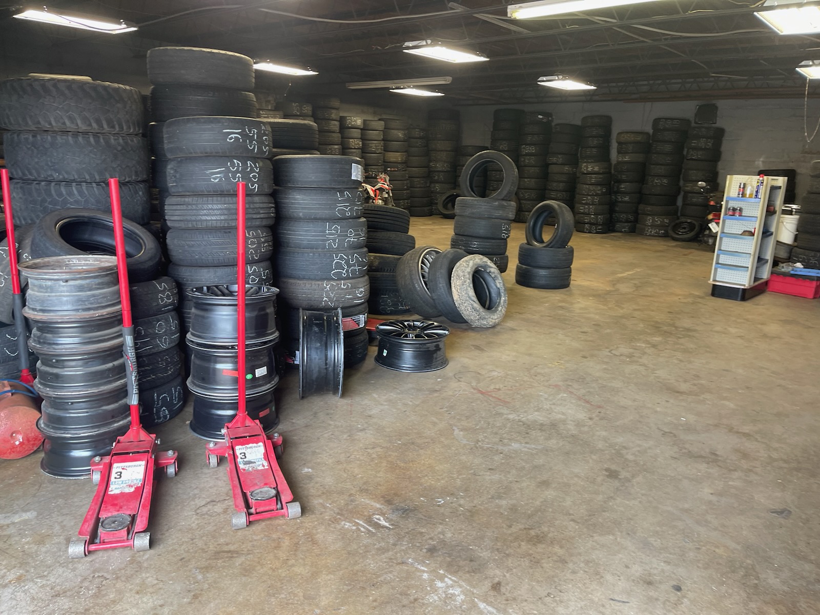 Used tires and wheels lined up inside the shop